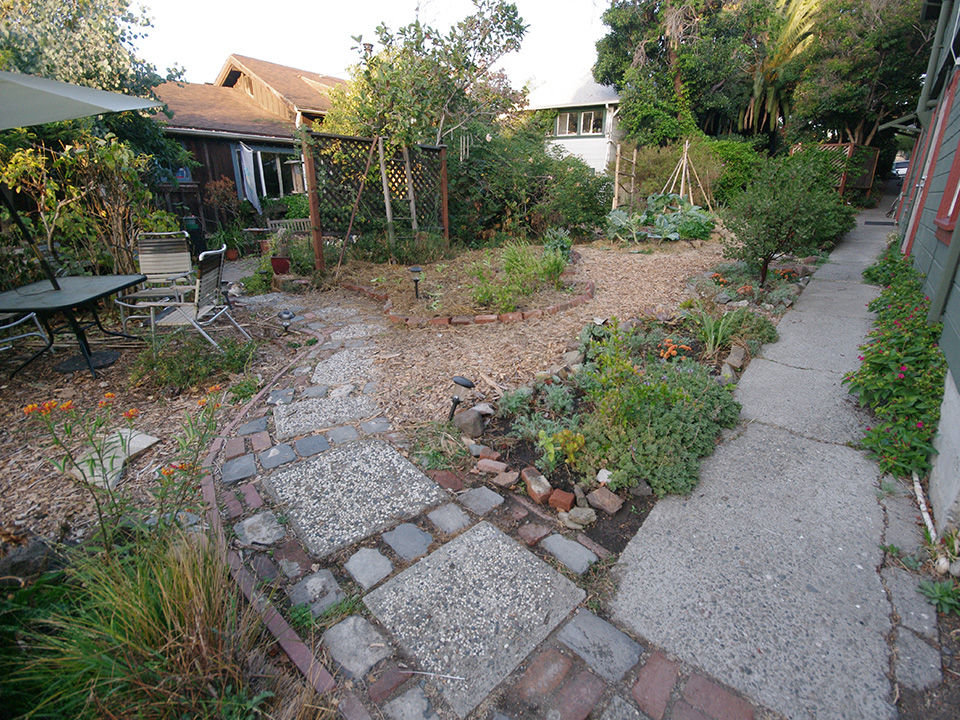 Community garden with pathways, plants, and outdoor seating at Canticle Farm.