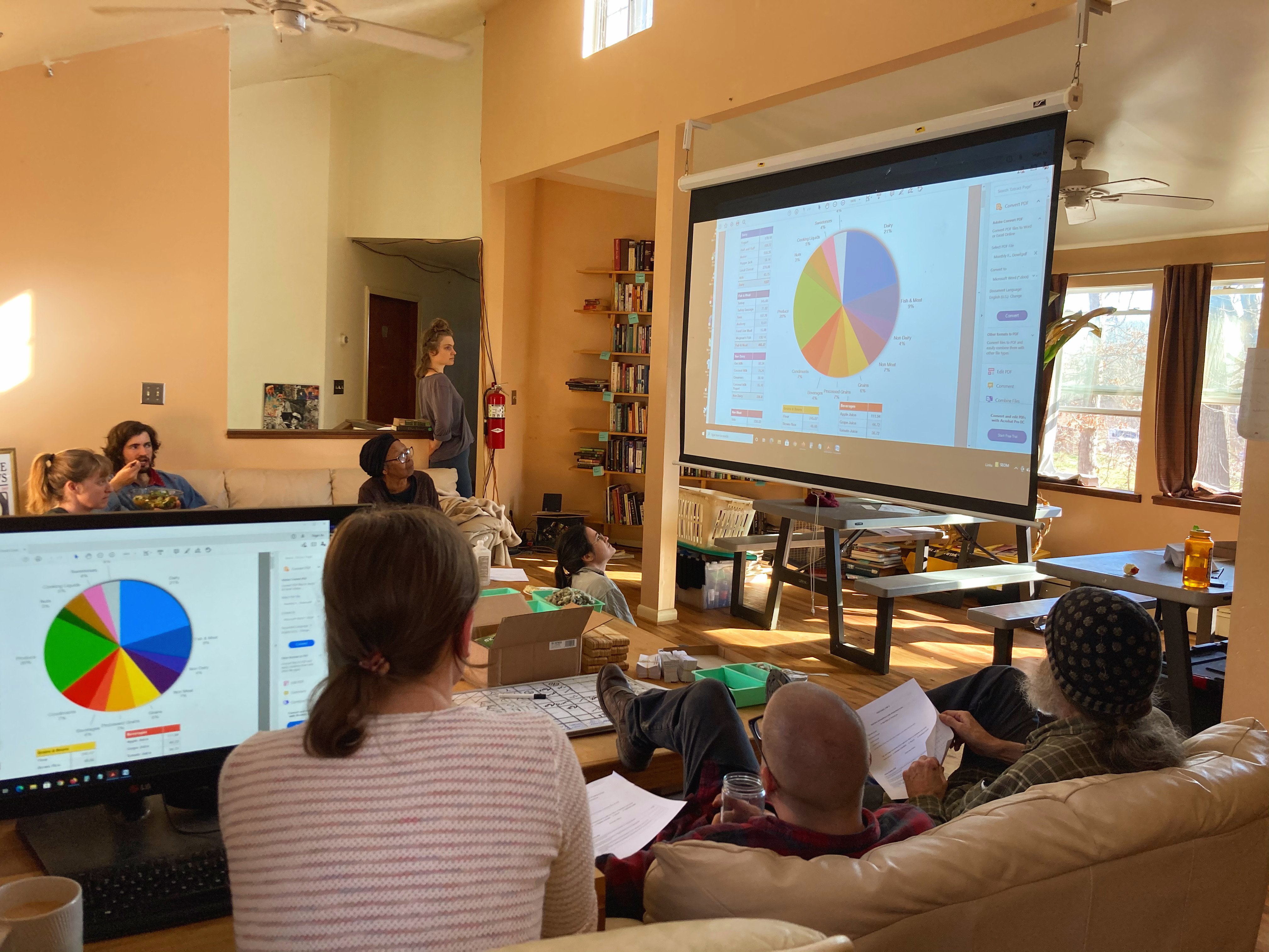People attending a community workshop with presentation slides and charts.