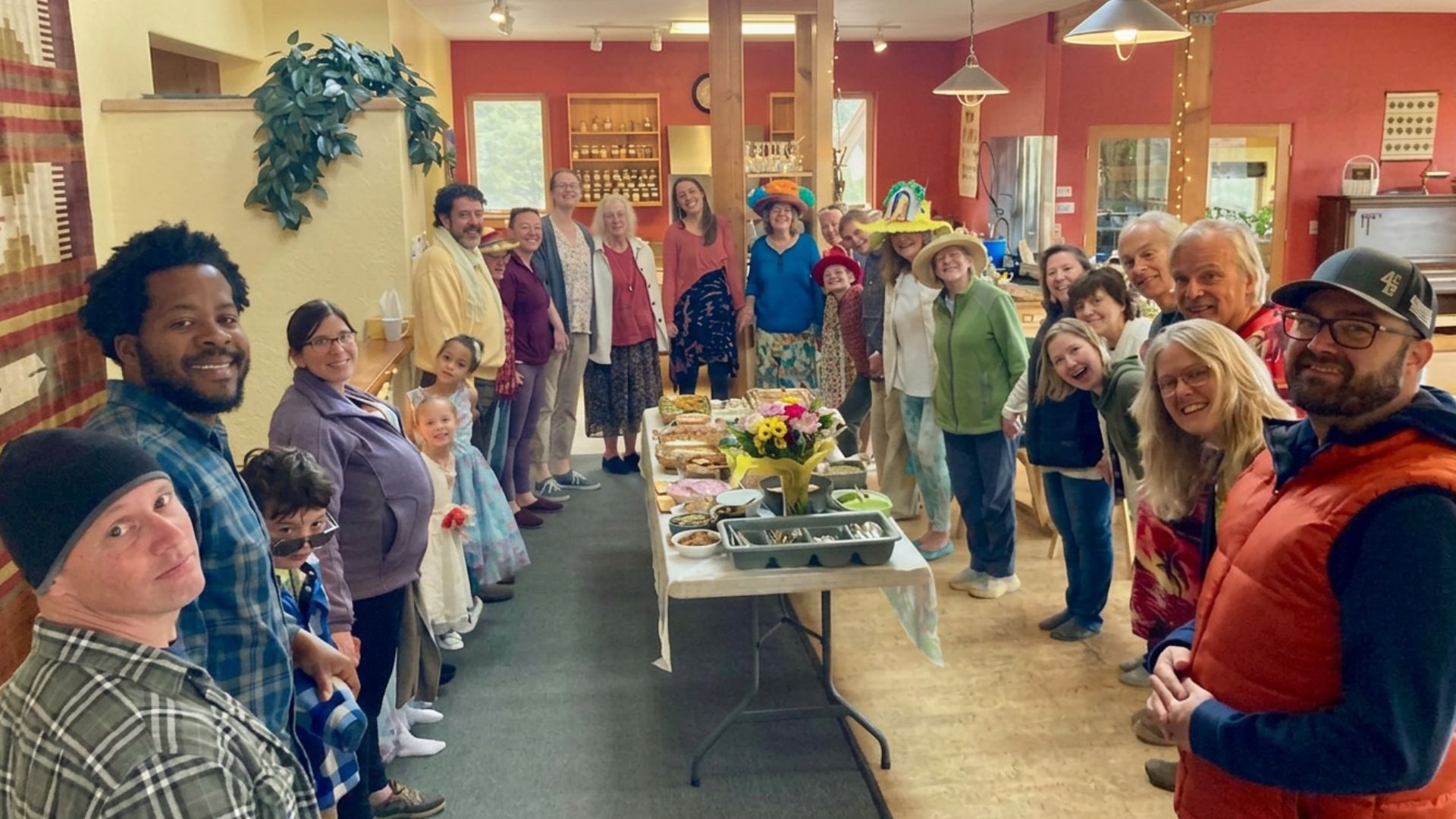 Group of diverse people gathered indoors for community event at Intentional Community.