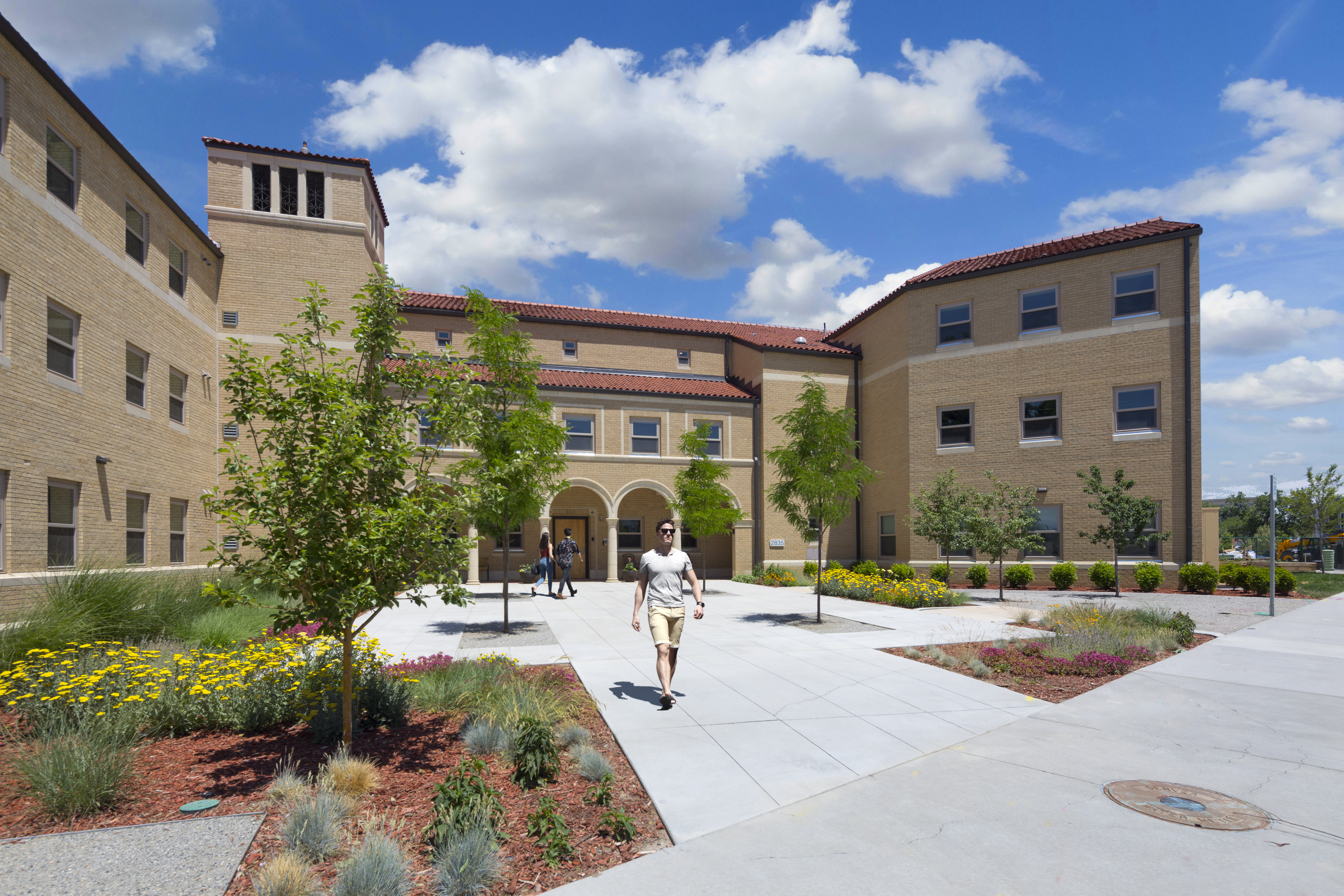 Modern cohousing community with landscaped courtyard and walking residents.