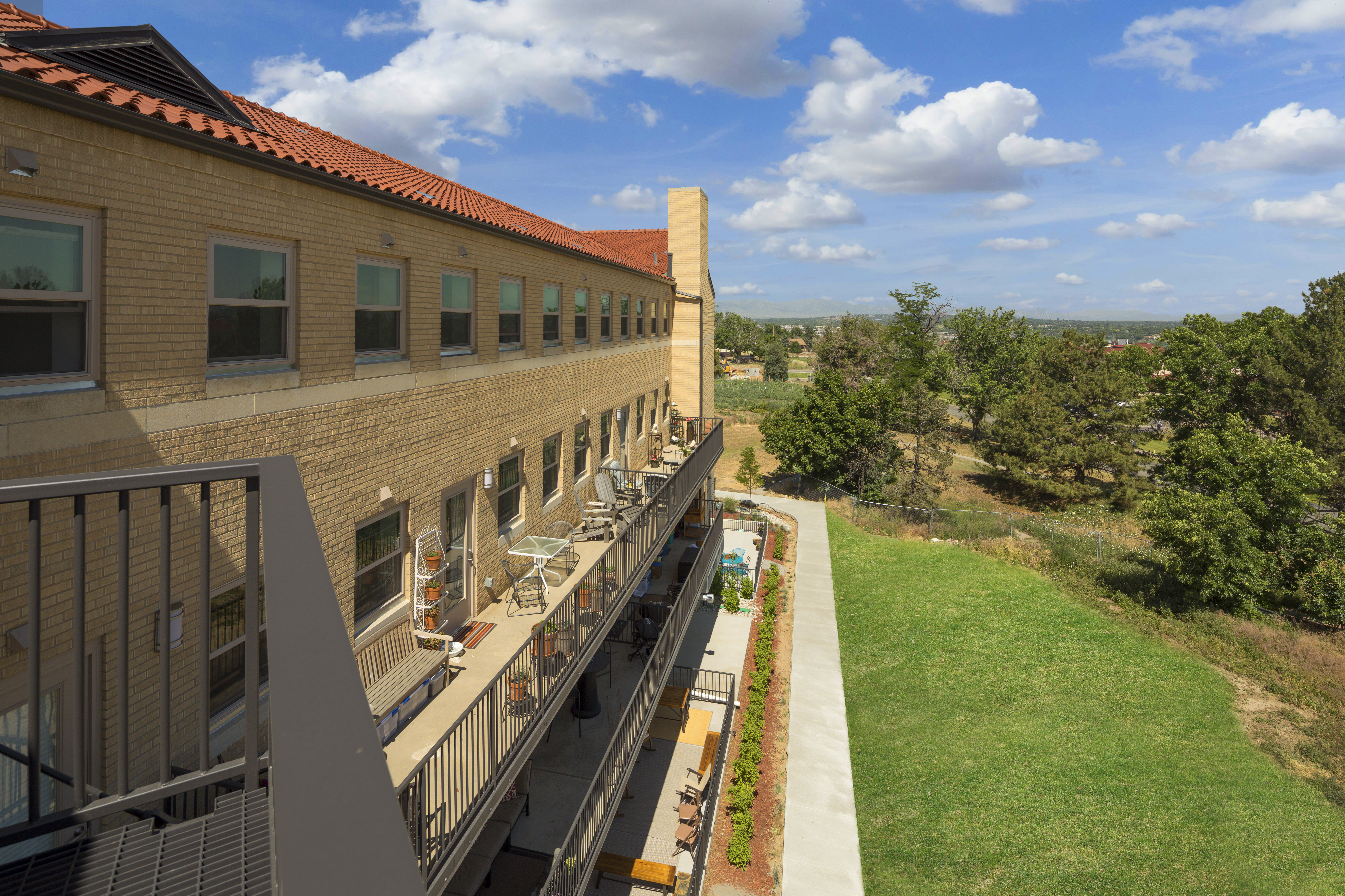 Modern cohousing building with balconies and green outdoor space.