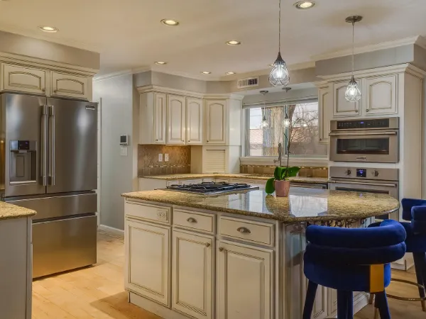 Spacious kitchen with white cabinets, granite countertops, and stainless steel appliances.