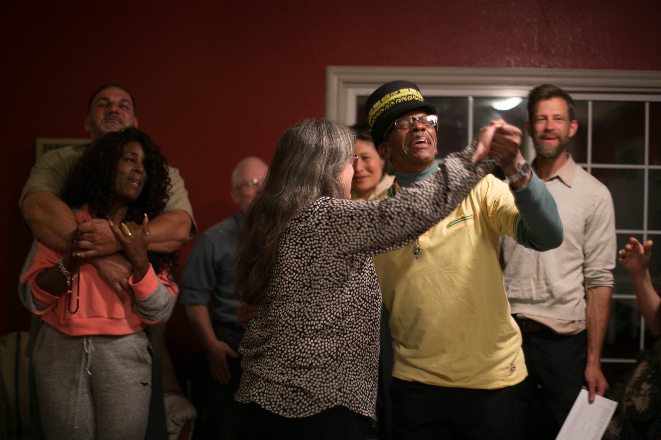 Diverse group of people dancing and celebrating indoors at Canticle Farm.